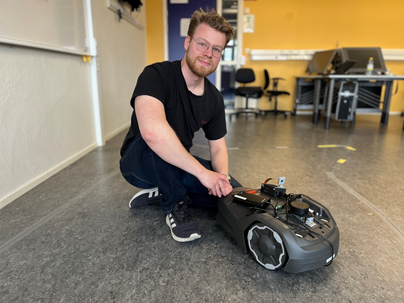 Student på Tekniska Högskolan vid robotgräsklippare. 